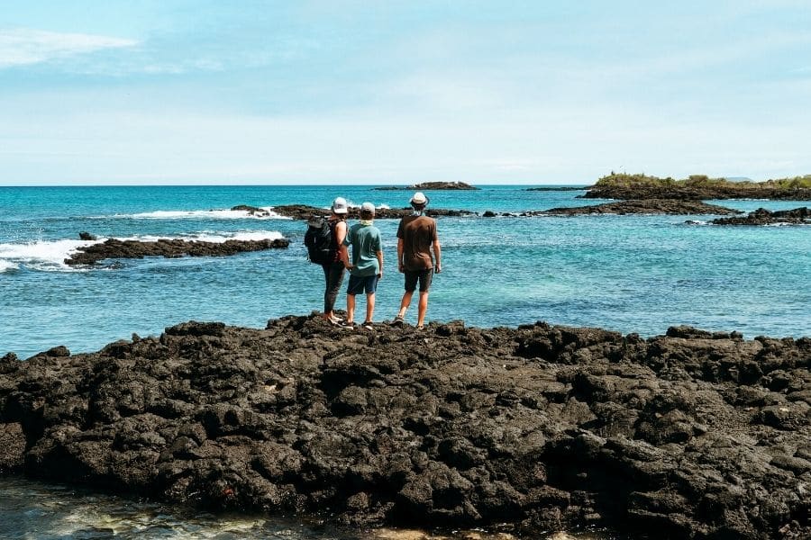 family watching the sea in the galapagos islands.