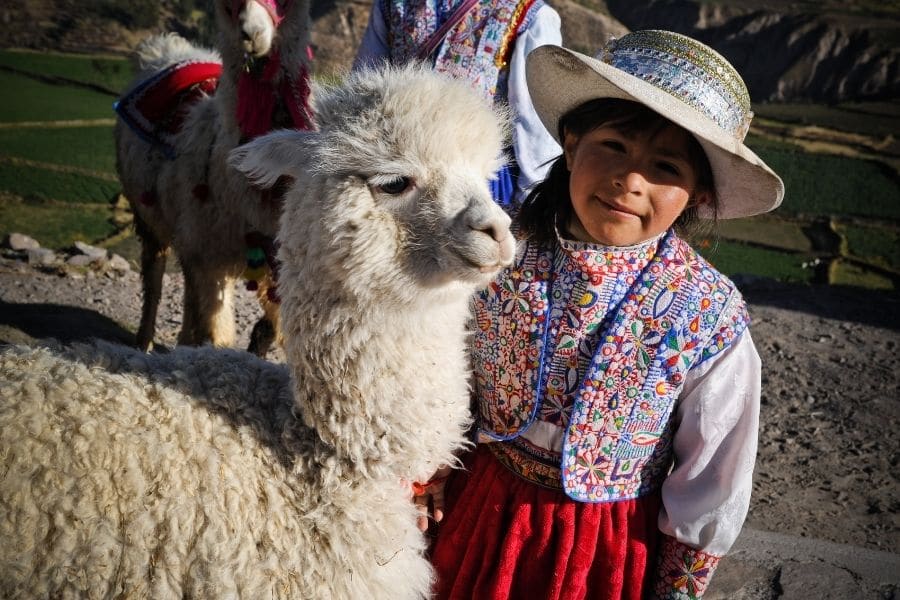 Indigenous girl from Peru with her pet alpaca